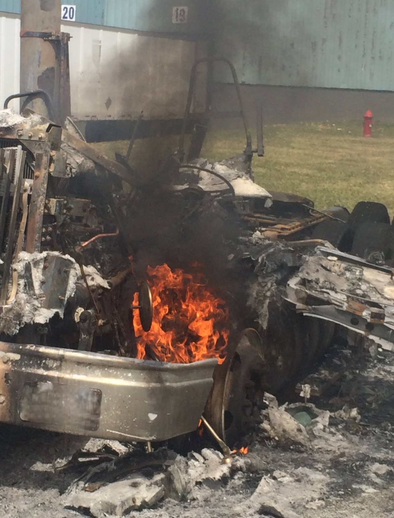 Severely burned yard truck with active wheel-area fire